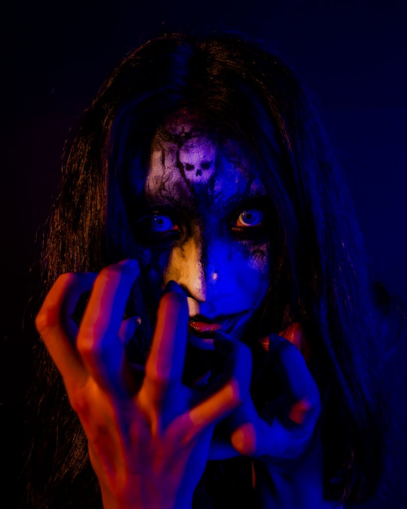 Eerie portrait in low light, featuring surreal makeup with horror elements.
